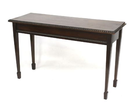 An Edwardian dark mahogany console hall table. With moulded edge decoration, on tapering square supports and a spade end foot