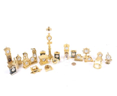 A collection of 22 brass cased miniature novelty clocks/timepieces. Including a ship's wheel, a street lamp, a golf bag and a