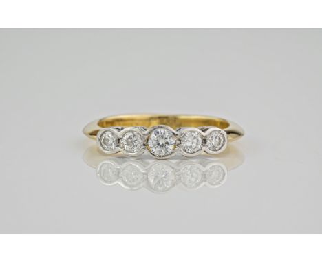 An 18ct yellow gold and diamond 5 stone ring, the stones held in an 18ct white gold rubover setting. Ring size L. 