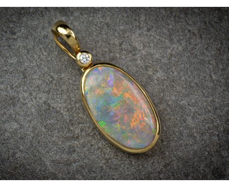 An 18ct gold, opal and diamond pendant, the oval, cabochon opal of good iridescence and orange, green, gold and blue colour, 