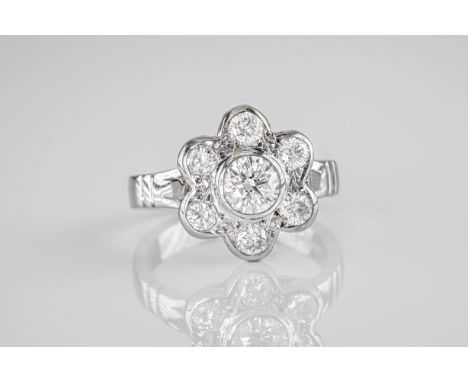 An 18ct white gold and brilliant cut diamond cluster ring, featuring 7 brilliant cut diamonds held in a flower shaped bezel s