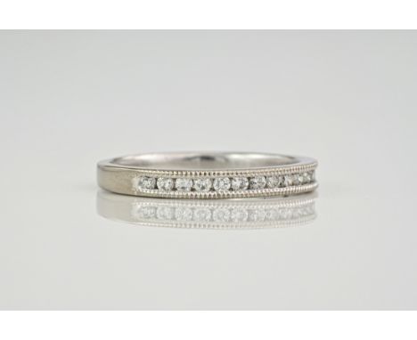 A platinum and diamond half eternity ring, the diamonds totalling 0.28ct and set with millegrain detailing. Ring size N. 