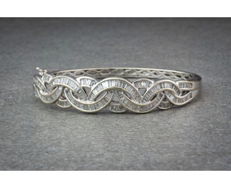 An 18ct white gold and diamond hinged bangle, en suite to lots 1273, 1274 and 1275, the graduated, interlaced elliptical link