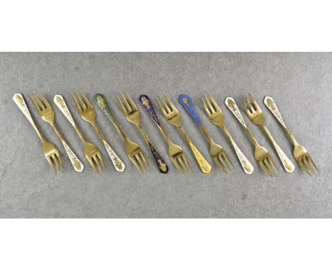 A collection of thirteen Thailand gilt metal and enamel miniature forks, each having Buddhistic enamel decorated shaped termi