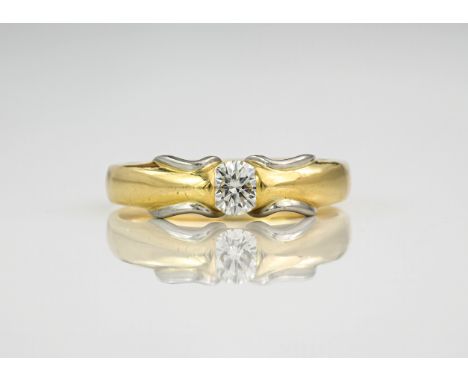 An 18ct yellow gold, platinum and diamond Millennium ring, the central diamond approximately 0.33ct and held in a tension set