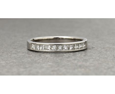 An 18ct white gold and diamond half eternity ring,&nbsp;channel set with eleven princess cut diamonds, size O.&nbsp;