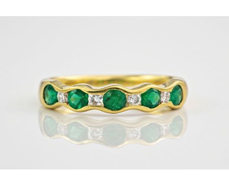 An 18ct yellow gold, emerald and diamond ring., Featuring 5 emeralds interspersed by 4 diamonds, ring size N. 
