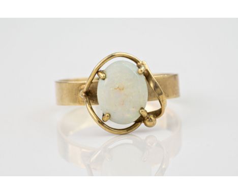 A vintage 9ct gold and opal ring, the white opal in an asymmetric open four claw setting, on a plain shank, size K½. 