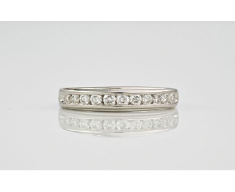 A 9ct white gold and diamond half eternity ring, featuring 11 round cut diamonds in a polished channel setting. Ring size K. 