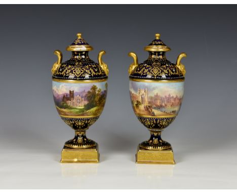 A fine pair of Coalport porcelain urn shaped vases with covers, early 20th century, of typical form with twin gilt mask handl