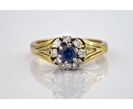 A 9ct yellow gold, sapphire and diamond cluster ring, the central round cut sapphire of approximately 0.33ct and with some we