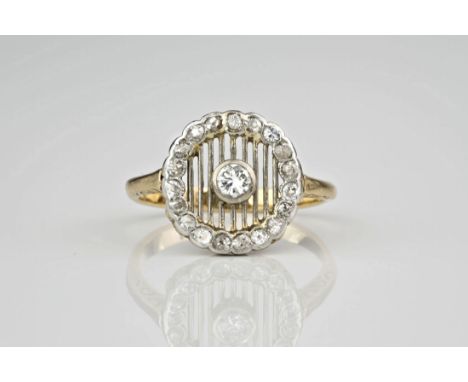 An Art Deco period 18ct yellow gold and diamond cluster ring, the central brilliant cut diamond seated upon a pierced grille,