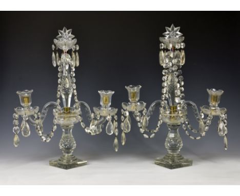 A pair of 19th century style cut glass two light candelabra, mid-20th century, the tall central sconce flanked by a pair of l