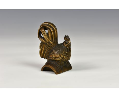 A Japanese carved wooden netsuke fashioned as a cockerel, probably early 20th century, having glass eyes and realistic featur