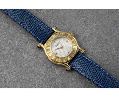 A lady's Gucci 6500L gold plated quartz wristwatch, with wave decorated silvered dial with quarter gilt baton markers, the ca