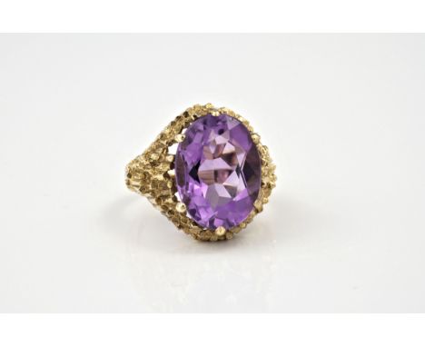 A modernist style 9ct gold and amethyst ring, hallmarked London 1971, the oval cut 15.5 x 12mm. amethyst in a bark effect set