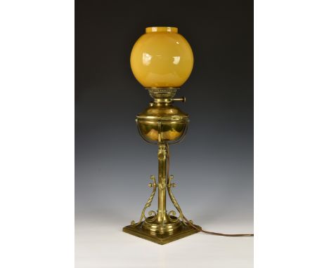 An antique English brass 'Lamp Belge' table lamp, c.1884, converted to electric, with orange / yellow shade, 25½in. (64.8cm.)