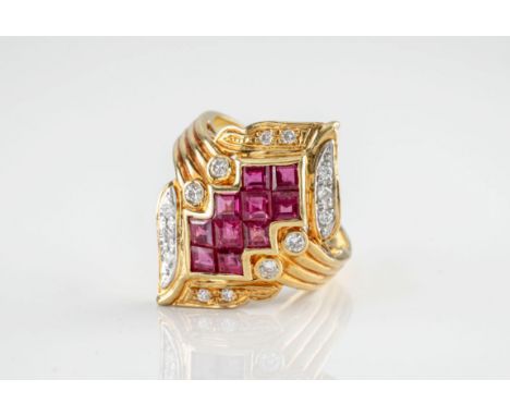 An 18ct yellow gold, ruby and diamond cocktail ring, featuring 10 calibré cut rubies held in an elaborate lozenge shaped sett