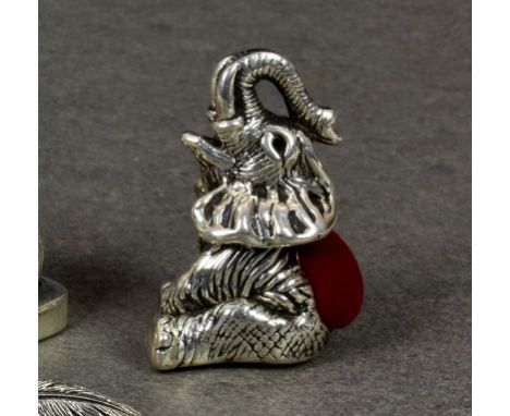 A modern novelty silver pin cushion fashioned as an elephant, stamped sterling, having red velvet pad, sitting on hind quarte