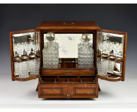 A Victorian Chapmans Patent 12481 oak-cased tantalus &amp; games compendium, the cabinet style box with twin opening front do