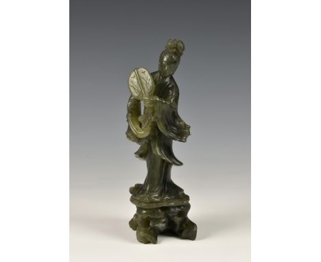 A Chinese carved jade style hardstone figure of Guanyin, second half 20th century, in mottled spinach stone, the figure in fl