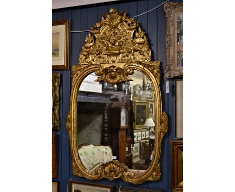 An 18th century style gilt and composition mirror, late 19th / early 20th century, the double c-scroll frame with laurel leaf