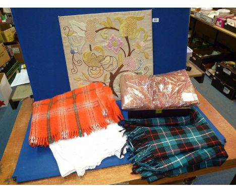 A quantity of miscellanea including two car rugs, a crewel work on board and a wool scarf.