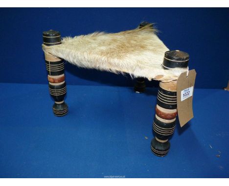 A triangular African Folk Art stool with goat skin seat, 14" wide x 10".