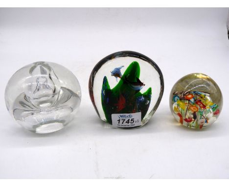 Three paperweights, Murano compressed circular glass having inner coral reef surrounded by six colourful fish and random bubb