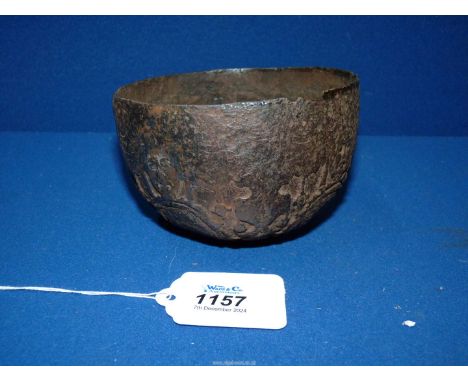 An interesting early iron drinking bowl cast and hammered with a design of grotesque masks, double headed eagles and portrait