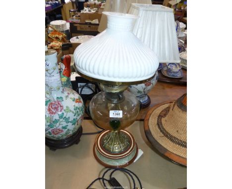 An oil lamp with ceramic base and amber glass reservoir with applied green decoration, white glass shade and chimney, 22" tal