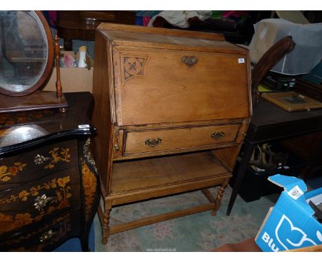 A 1930/40's mid/light Oak Bureau, the fall front revealing an interior with four recesses and having a frieze drawer and a sh