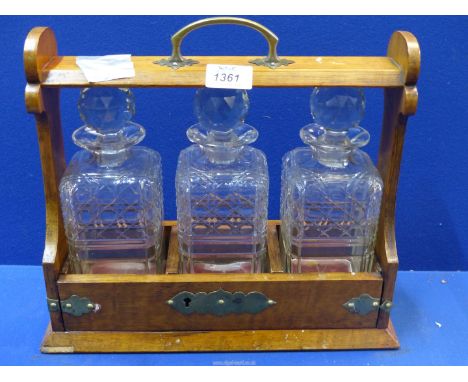 A Tantalus with square cut decanters, with key but not opening at time of lotting.