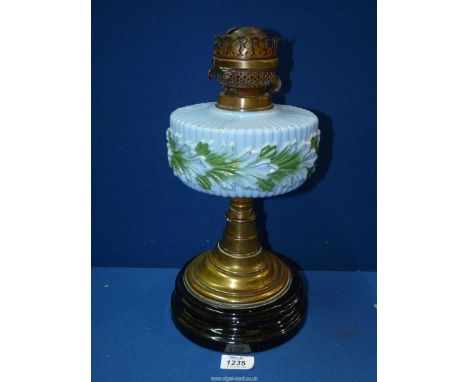 An Oil lamp having a ceramic base and opaque blue glass reservoir with green highlights, 14" tall. (no chimney present).