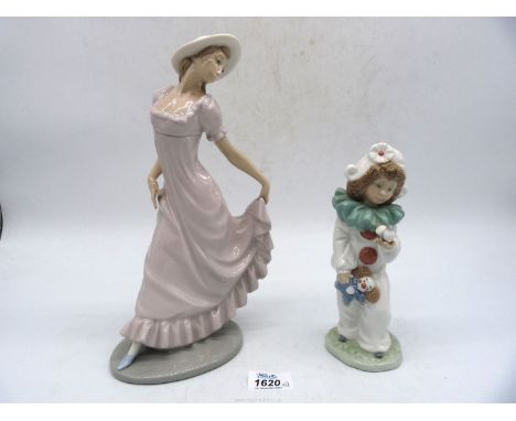 Two Nao figures of a child dressed as a clown and a young girl in a pink dress.