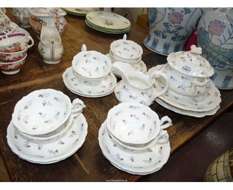 A part eight person tea service detailed with stylized sprigs to include: eight cups and saucers, three cake plates, a milk j