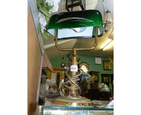 A brass banker's lamp with green shade.