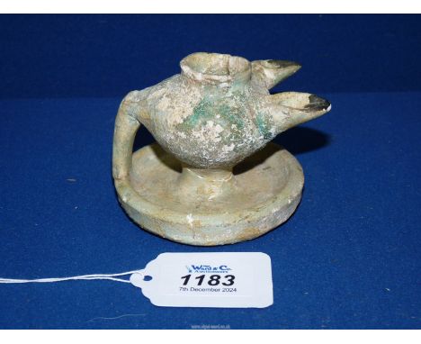 A fine early Islamic two spouted terracotta oil lamp, 11th-12th century with blue glaze typical of Kashan wares, 2 3/4" tall.