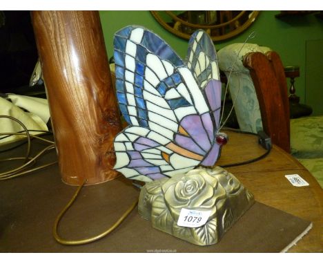 A Tiffany style lamp in the form of a butterfly in purples and orange, 9 1/2" tall.