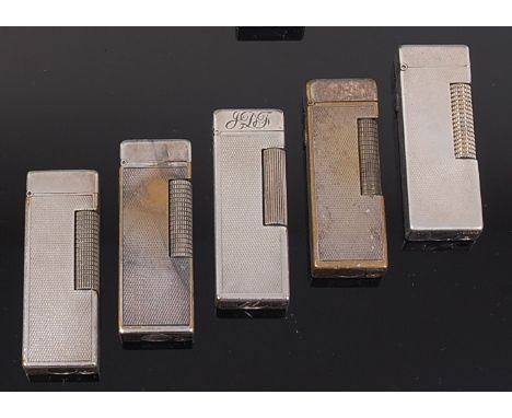 Five 1950s Dunhill silver plated engine turned pocket lighters, each with hinged covers, patent numbers; 24513, 5713, 726982,