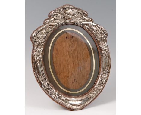 An Art Nouveau floral silver embossed oval easel photograph frame, of good size, the top surmounted by a butterfly, housed on