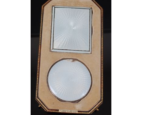 An Art Deco silver and guilloche enamel pocket cigarette case with matching circular powder compact, each housed in a fitted 