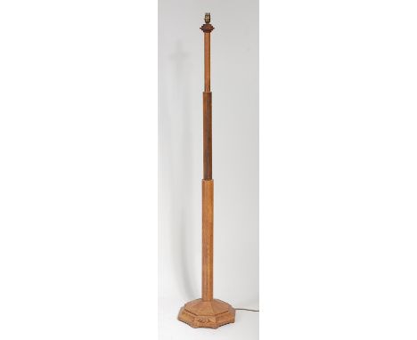 After Robert 'Mouseman' Thompson - A light oak standard lamp, the column of octagonal stepped form over further octagonal bas