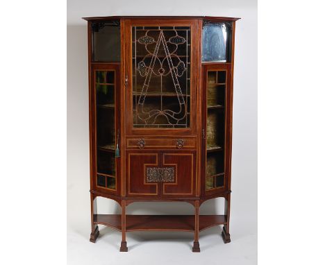 An Art Nouveau, probably Glasgow School mahogany, inlaid and copper mounted display cabinet, having leaded and colour glazed 