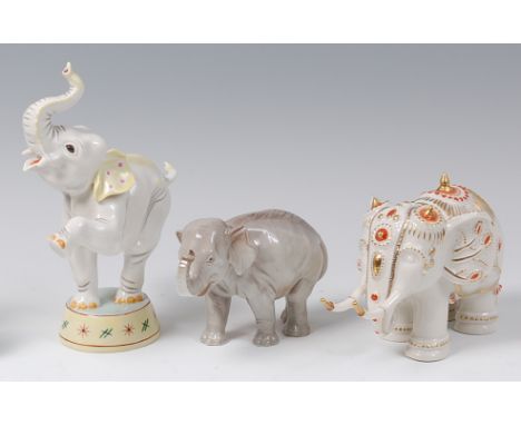A Nymphenburg glazed porcelain model of a circus elephant, its trunk raised and standing on pedestal, heightened in colour, i