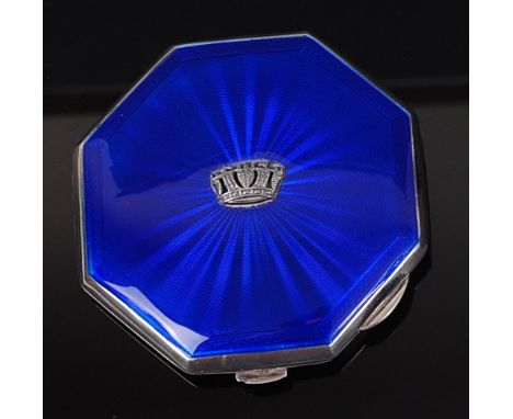 An Art Deco silver and blue guilloche enamel octagonal powder compact, the cover with applied crown motif, the interior with 