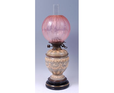 A Doulton Lambeth glazed stoneware pedestal oil lamp, having etched pink glass globe, the removable top section with glass bo