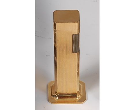 A Dunhill gold plated tallboy table lighter, the engine turned exterior with canted edges and typical hinged lid, stamped mar