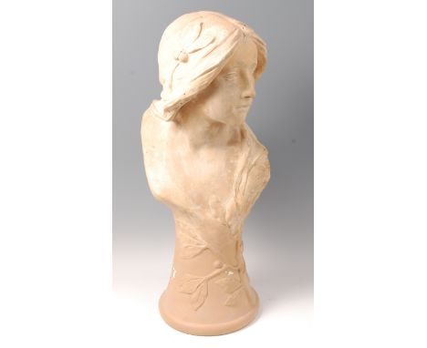 A large Art Nouveau painted plaster pedestal bust of a young woman, decorated with leaves and berries, indistinctly signed Si