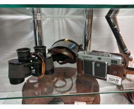 A pair of Zeiss 8 x 30 binoculars and a voigtlander camera.